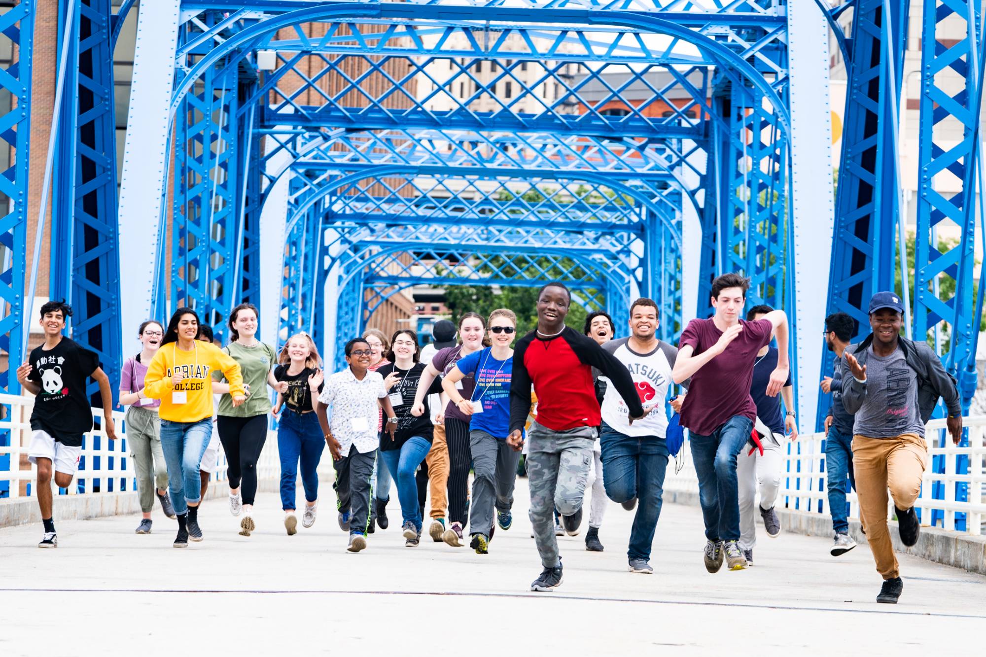 Students running enthusiastically across the Blue Bridge